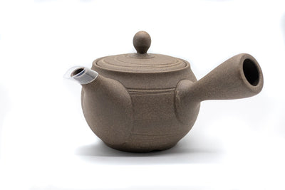 Front of light-brown clay Japanese tea pot (kyusu) made in Tokoname, with a side handle.