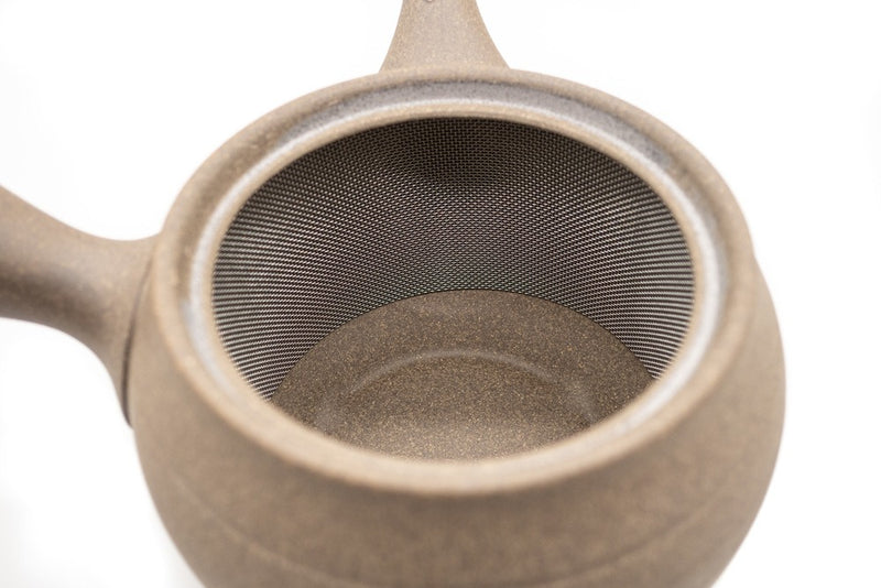 Inside view of a light-brown clay Japanese tea pot (kyusu) made in Tokoname, showing its integrated stainless steel mesh.