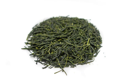 Needle-shaped and deep emerald green dento hon gyokuro leaves from Yame, Japan, in a circle shape.