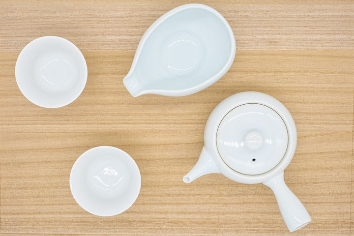 Service à thé de quatre pièces en porcelaine blanche fabriqué à Arita, au Japon, pour infuser le thé vert gyokuro, avec une petite théière (kyusu), un refroidisseur d'eau et deux tasses.