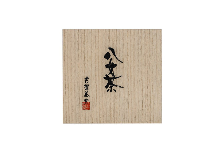 Vue de dessus d'une grande boîte carrée en bois sur laquelle est inscrite une calligraphie japonaise à l'encre noire.