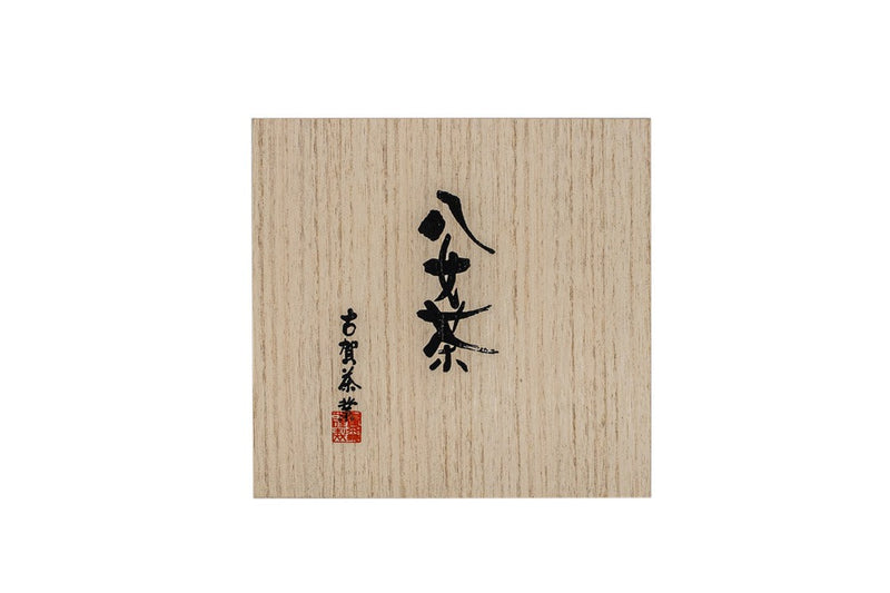 Top view of a large square wooden box with Japanese hand calligraphy written on it in black ink.